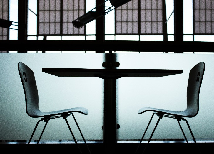 Foto: unsplash.com. Bildē attēlota radio studija ar krēsliem un mikrofoniem, bez cilvēkiem. 