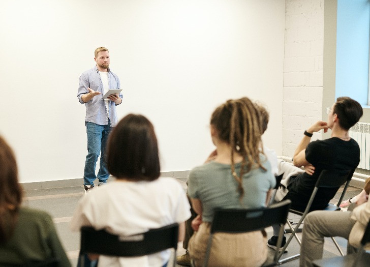 Seminārā auditorijas priekšā stāv tā vadītājs. Autors: pexels.com
