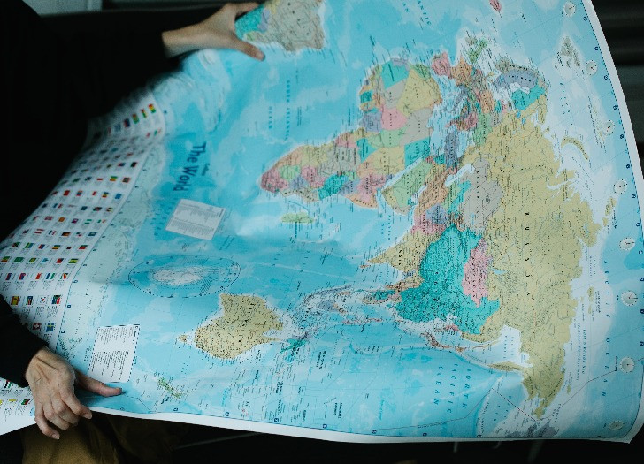 A person is holding a world map