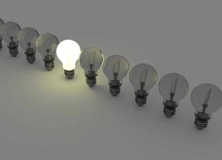 spuldzīšu rinda ar vienu iedegtu spuldzi vidū. Foto: unsplash.com